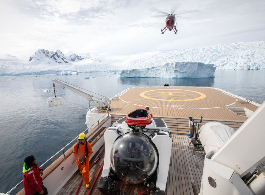 Submersible and firefighters aboard superyacht in Antarctica with helicopter taking off