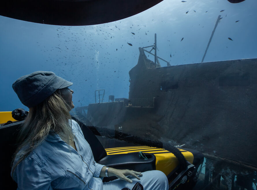 Woman looking out of a submersible at a wreck in Malta