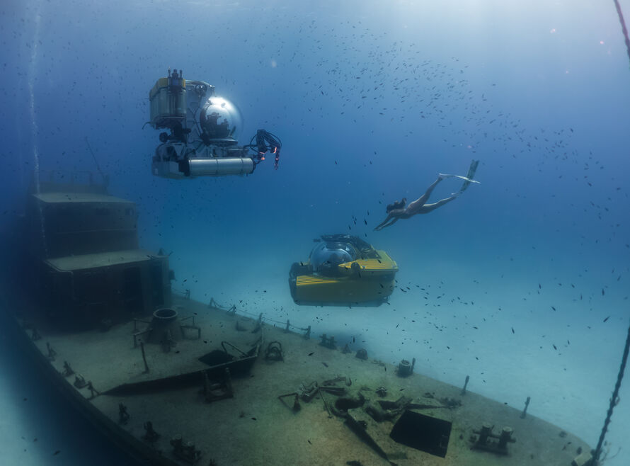 Two submersibles and a freediver, diving on a wreck in Malta