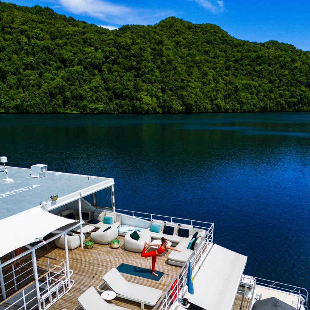 Woman doing yoga on the deck of a yacht in Palau