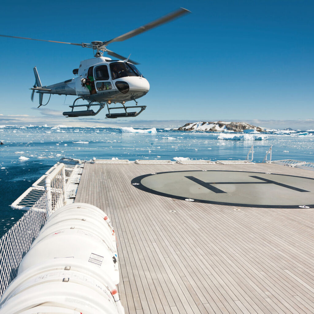 Helicopter landing on superyacht in Antarctica