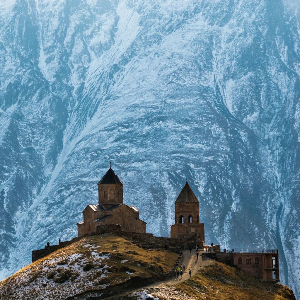 Church on top of a mountain in front of a snowy mountain